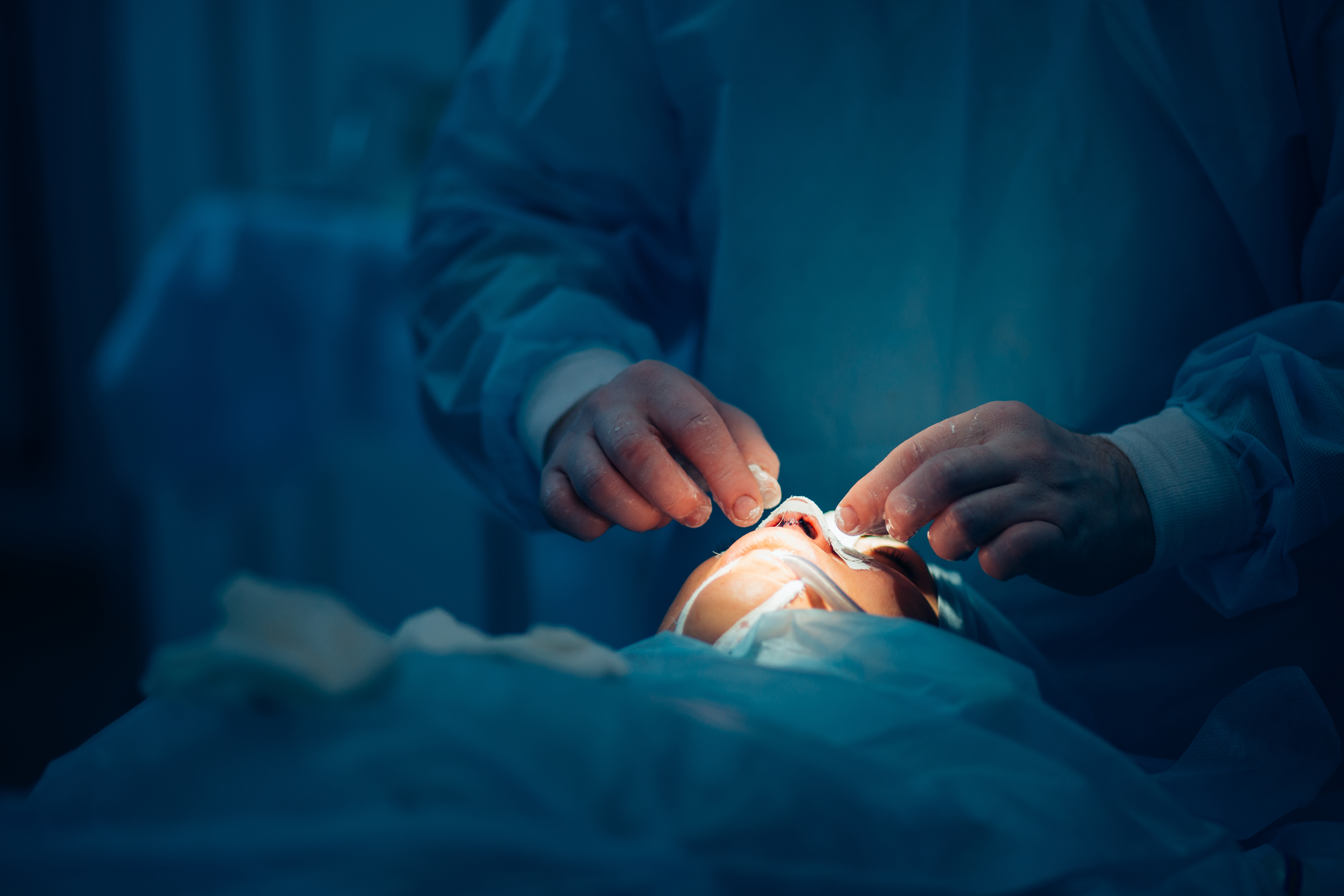 Surgeon,And,His,Assistant,Performing,Cosmetic,Surgery,On,Nose,In