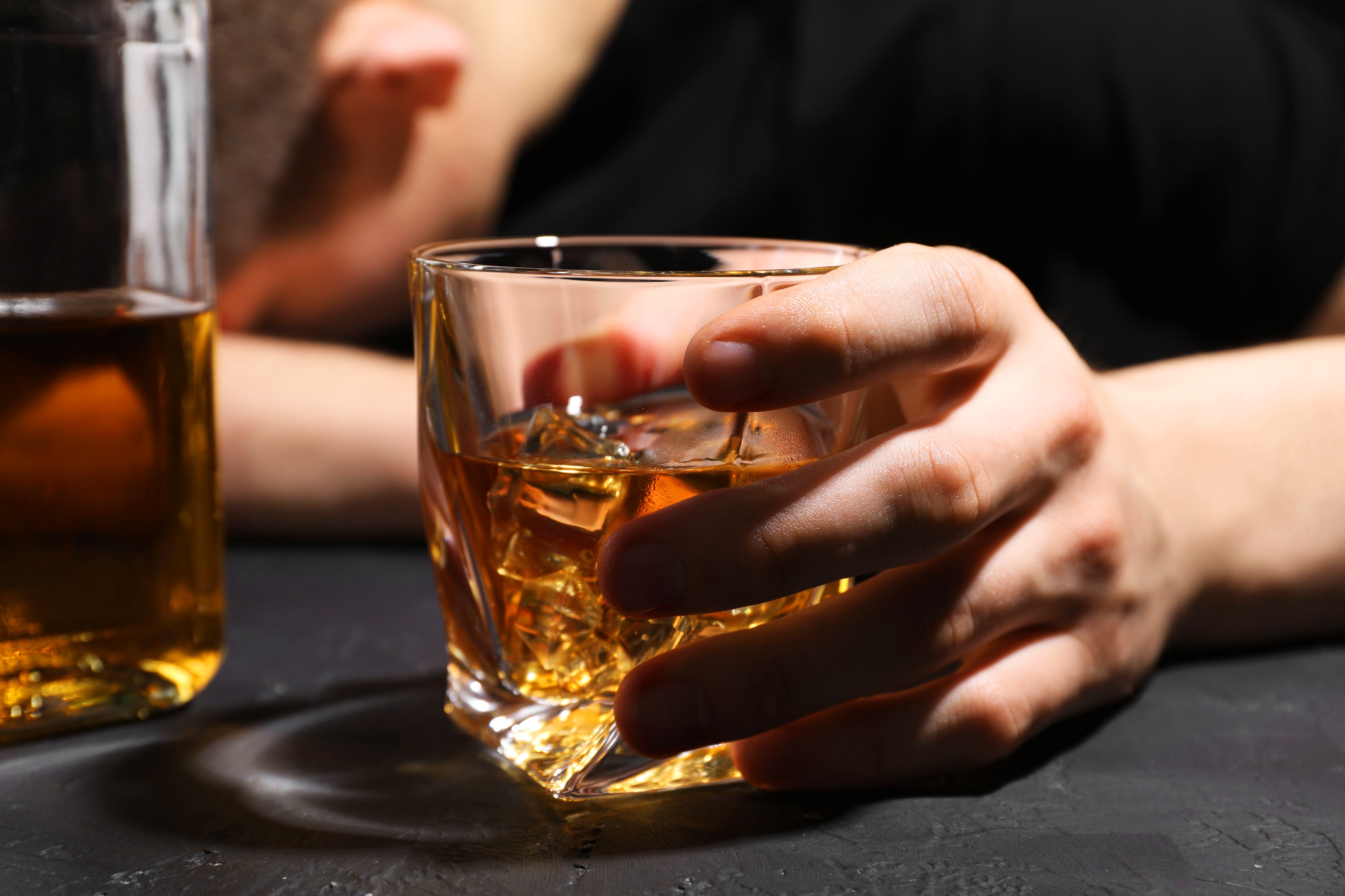 A person holds an alcoholic drink. 