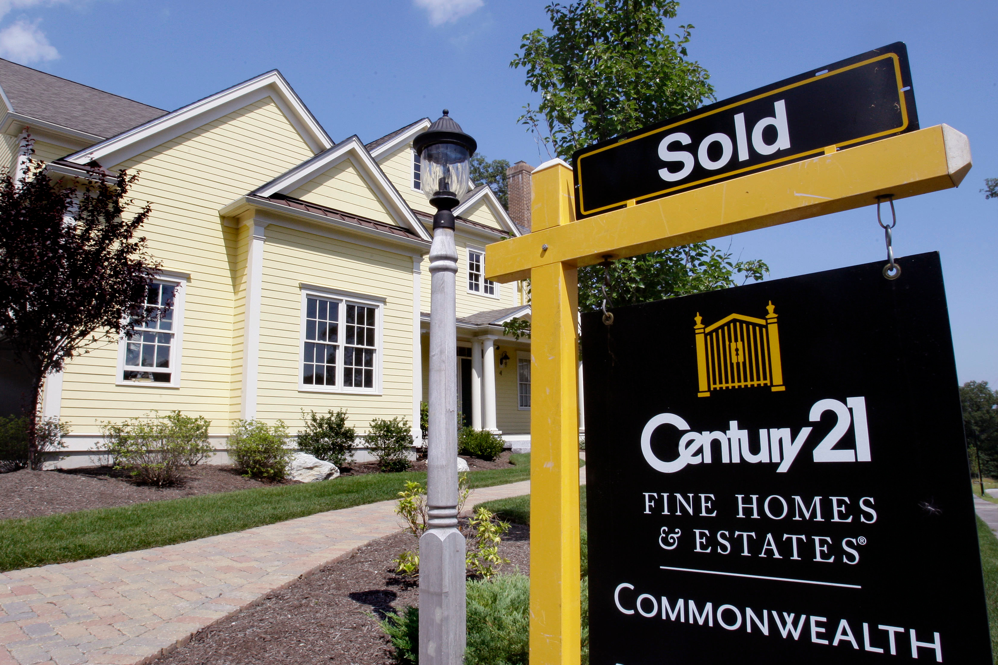 FILE - A sold sign is posted outside a newly constructed luxury home in Wellesley, Mass.