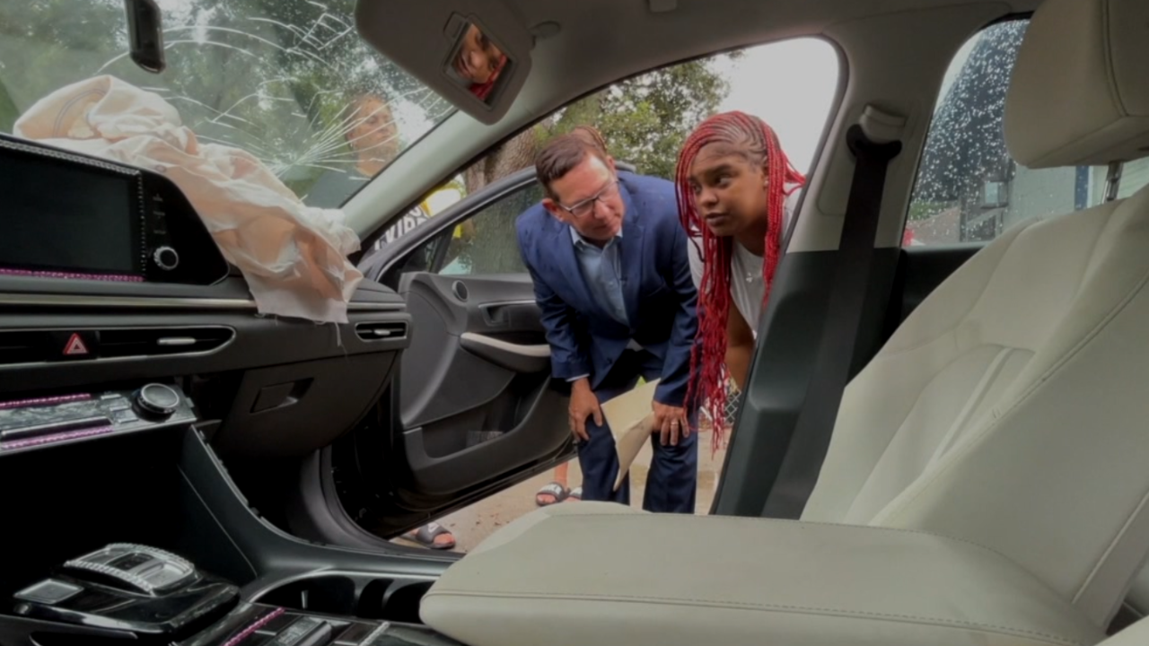 Bella Bankston shows how her airbags deployed when a police cruiser plowed into her car.