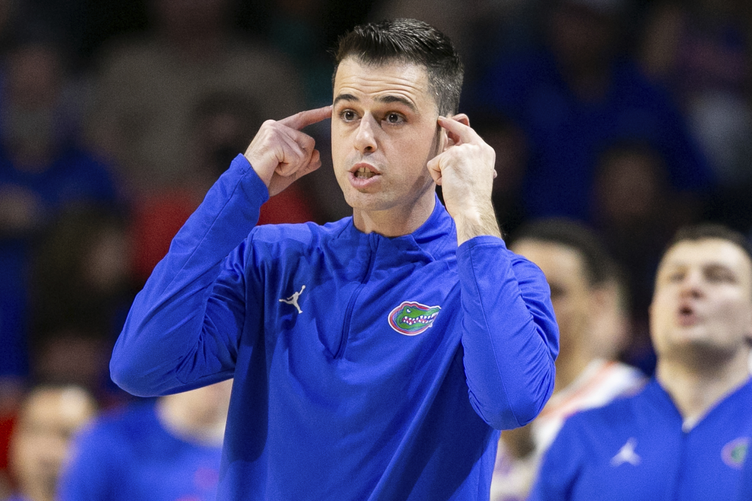 Florida Gators basketball coach Todd Golden points to his head during second half vs. Auburn, Feb. 10, 2024