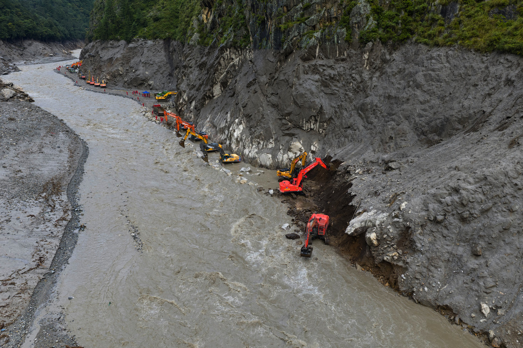In this photo released by Xinhua News Agency, workers use excavators to move mud from a road damaged by mudslide in Gyirong County, southwestern China's Tibet Autonomous Region on Monday, Aug. 31, 2026. 