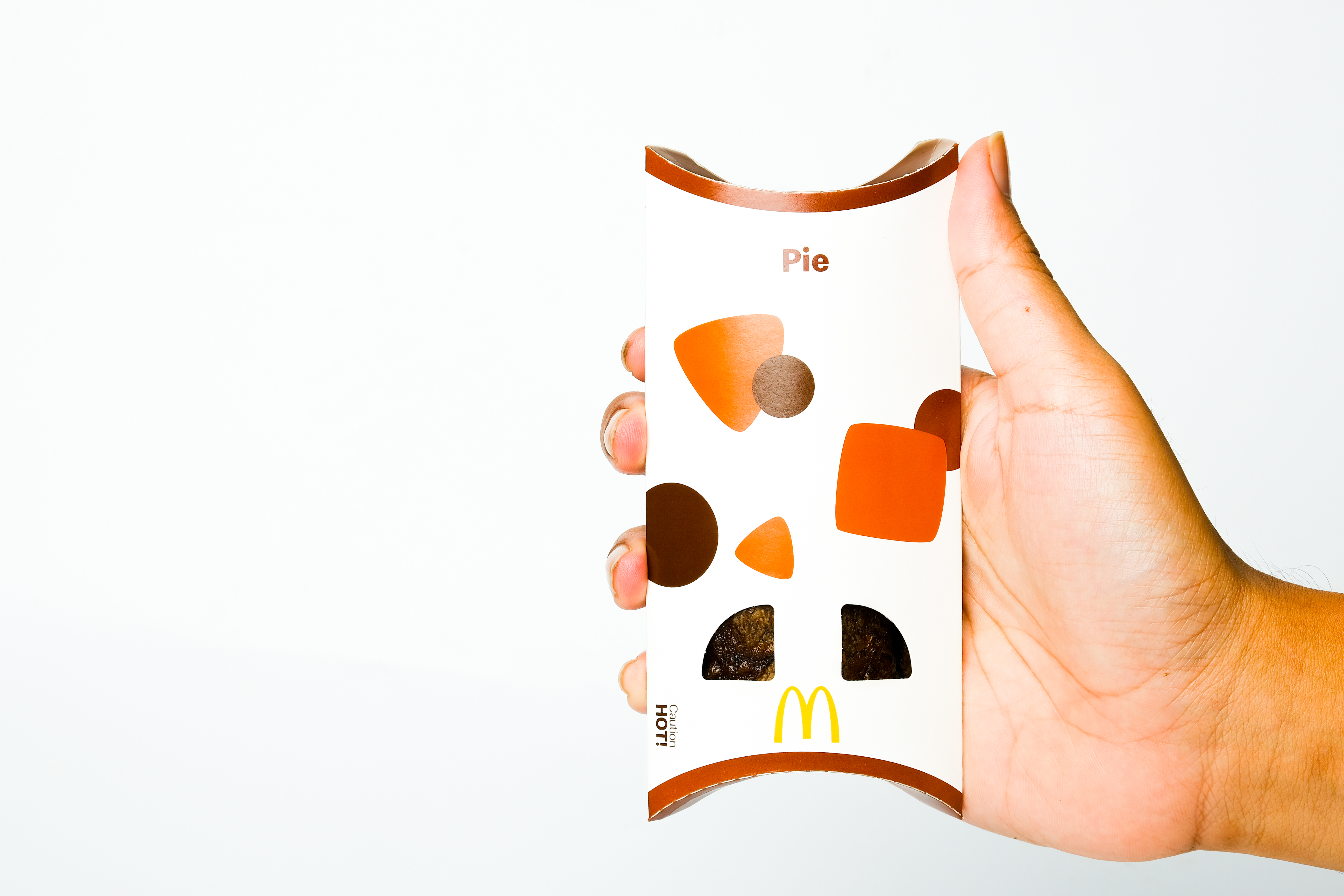 A hand holding a McDonald's pie.