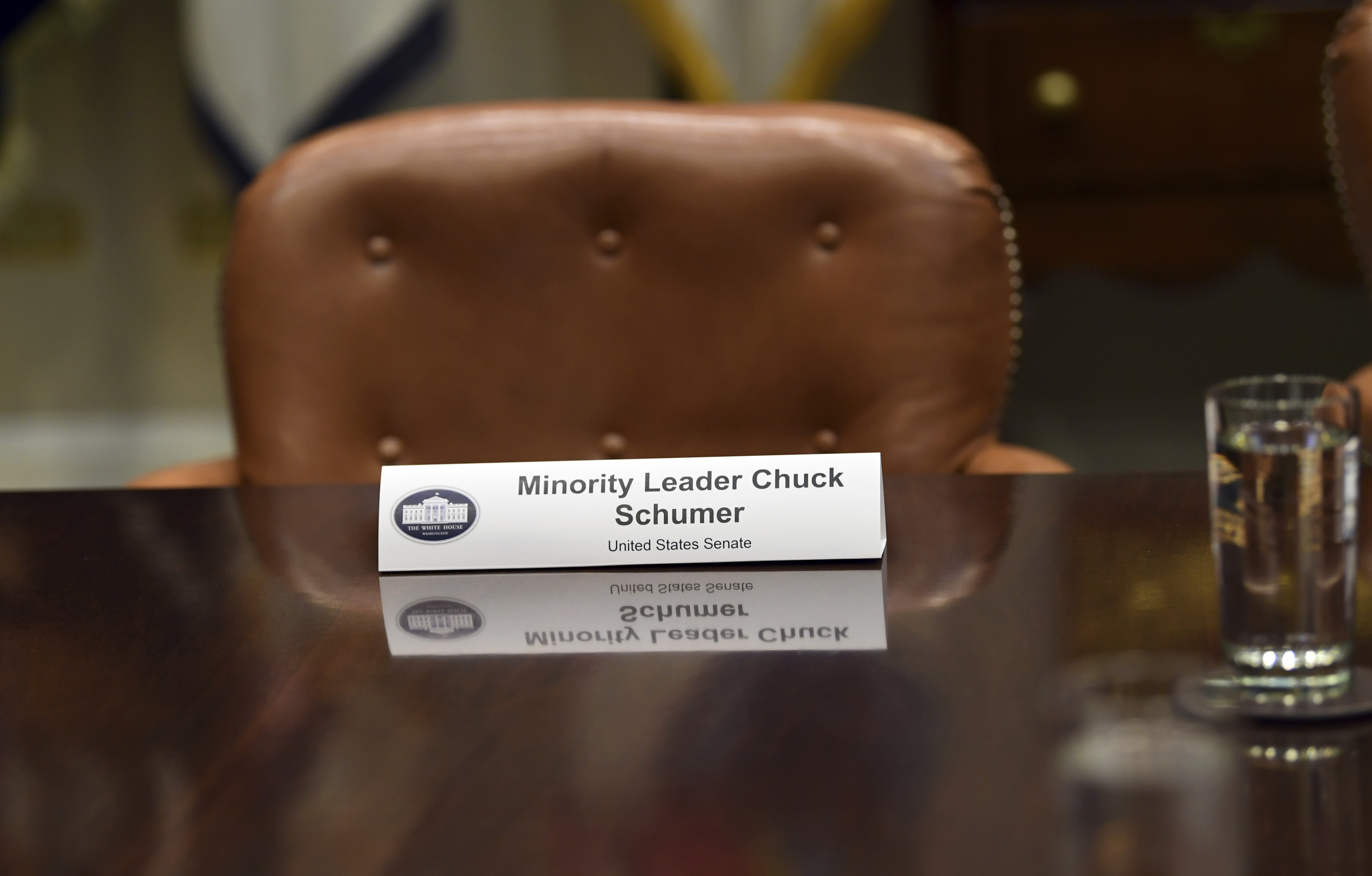A place for Senate Minority Leader Sen. Chuck Schumer of N.Y., is marked as President Donald Trump speaks in the Roosevelt Room of the White House in Washington, Tuesday, Nov. 28, 2017, during a meeting with Republican congressional leaders. Schumer and House Minority Leader Nancy Pelosi of Calif., did not attend the meeting. 
