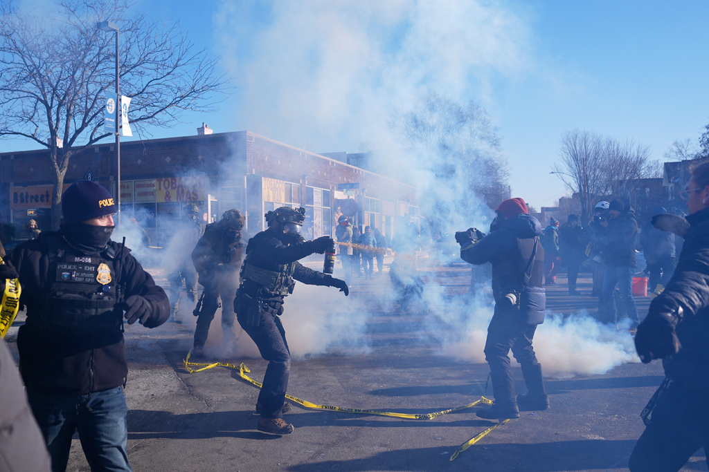 Federal immigration officers deploy tear gas at protesters after a shooting Saturday, Jan. 24, 2026, in Minneapolis.