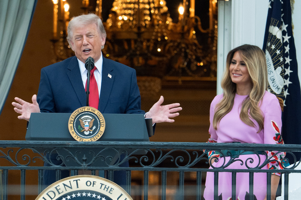 President Donald Trump with first lady Melania Trump addresses the attendees from the Blue Room Balcony of the White House during the annual Congressional Picnic on the South Lawn, Tuesday, May 19, 2026, in Washington. 