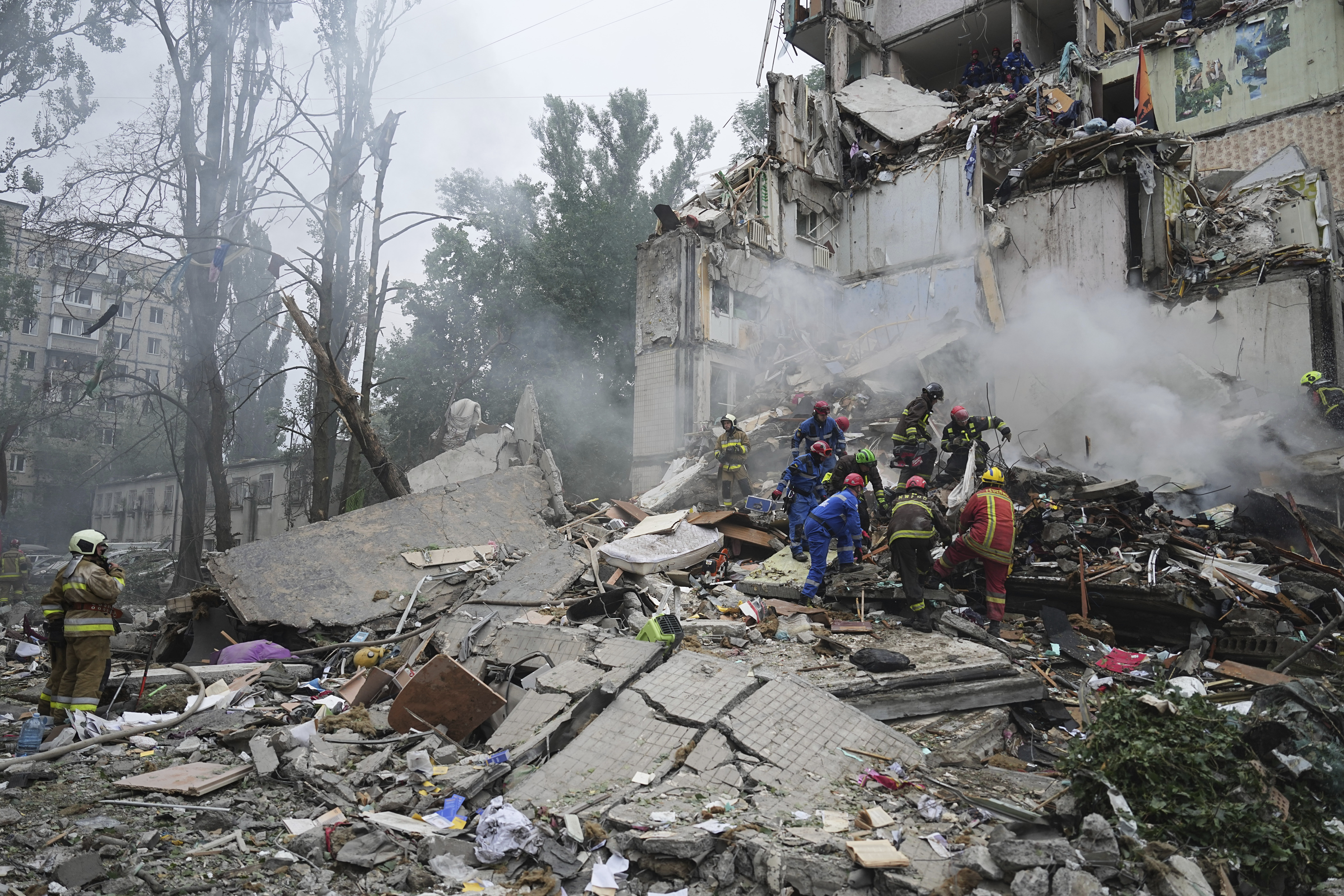 Rescuers work in a destroyed apartment building after a Russian missile attack in Kyiv, Ukraine, Thursday, July 31, 2025.