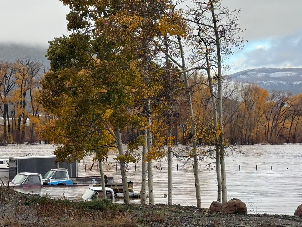 Pickup trucks are submerged along Highway 160 in South Fork, Colo., on Friday, Oct. 23, 2026. 