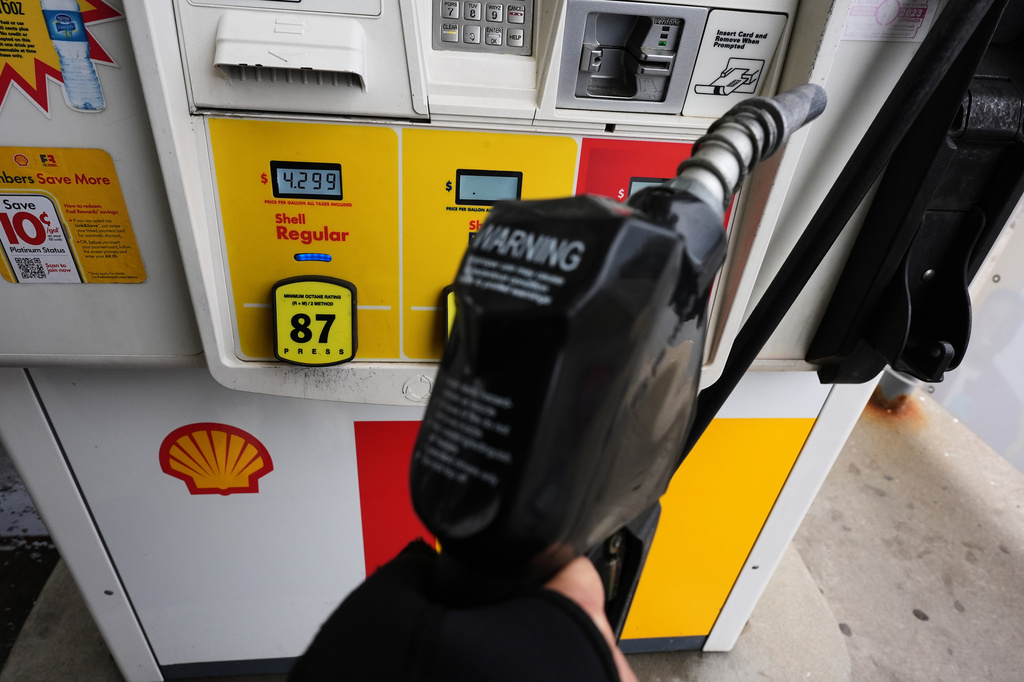 FILE - A gas price is displayed as a customer holds a fuel pump nozzle before filling up her vehicle's gas tank at a gas station, in Lincolnshire, Ill., Wednesday, April 15, 2026. 