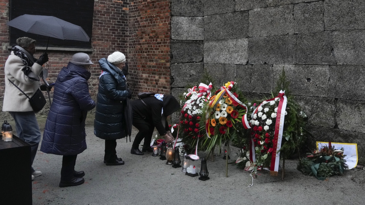 Holocaust survivors and relatives light candles at the Death Wall in the Auschwitz Nazi death camp in Oswiecim, Poland.