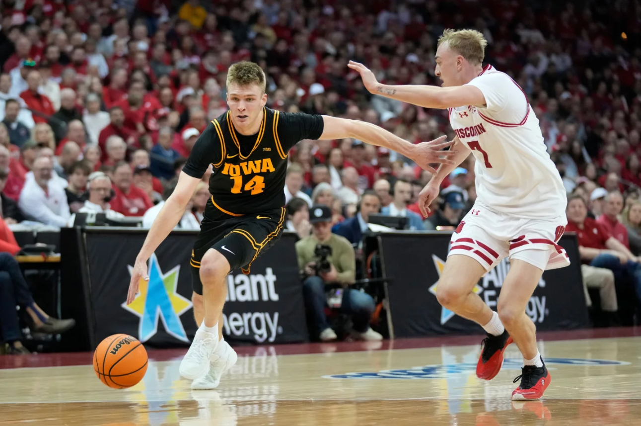 Iowa guard Bennett Stirtz (14) dribbles against Wisconsin guard Andrew Rohde, right, during the first half of an NCAA college basketball game Sunday, Feb. 22, 2026, in Madison.