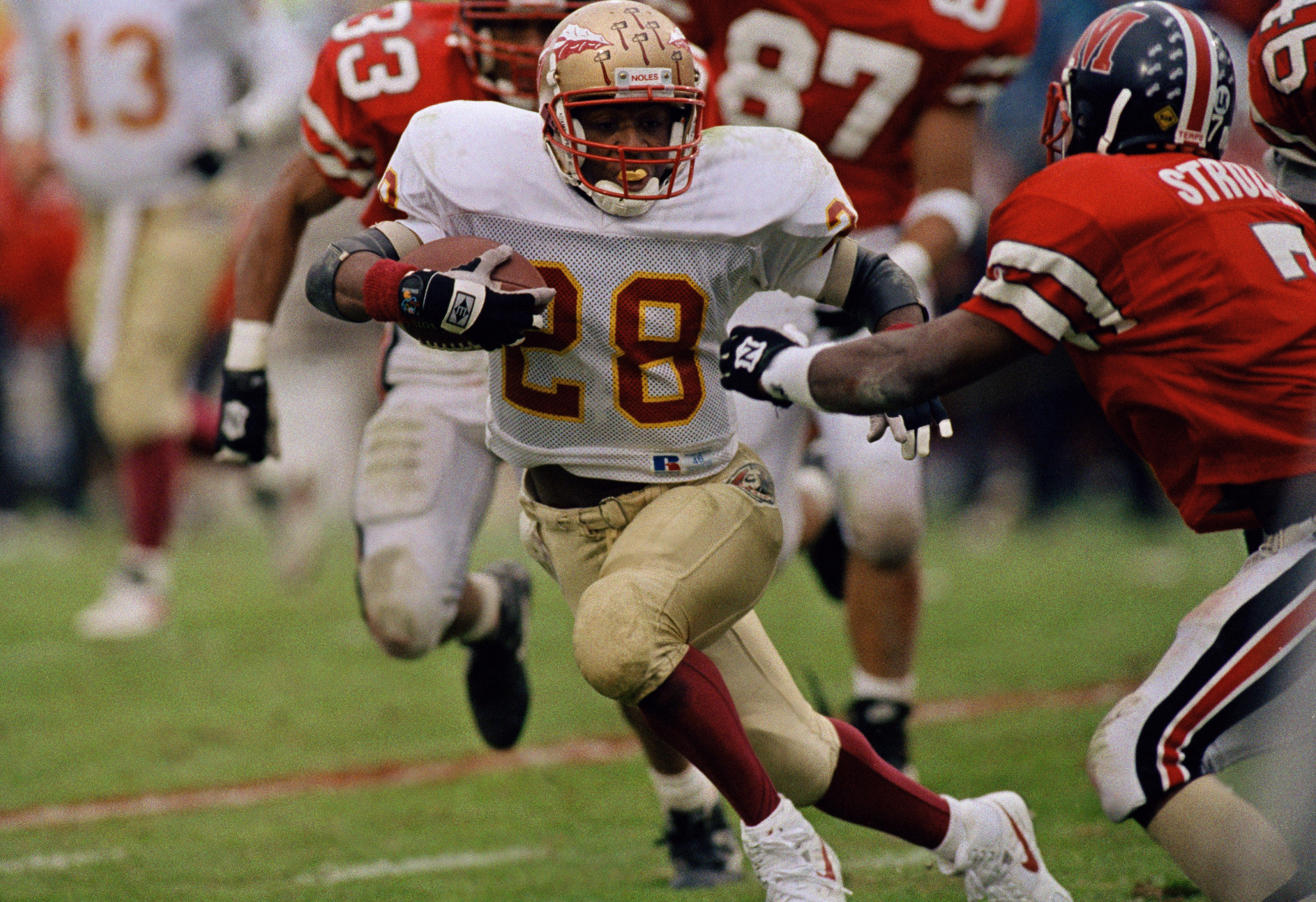 Florida State Seminoles running back Warrick Dunn tries to get away from Maryland Terrapins cornerback Orlando Strozier, Nov. 6, 1993