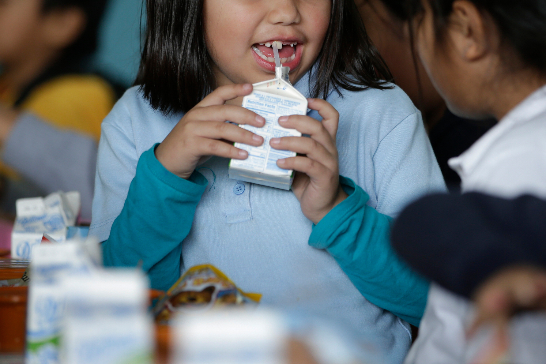 FILE - A student drinks milk in the cafeteria area of an elementary school in Los Angeles on Tuesday, Jan. 13, 2015