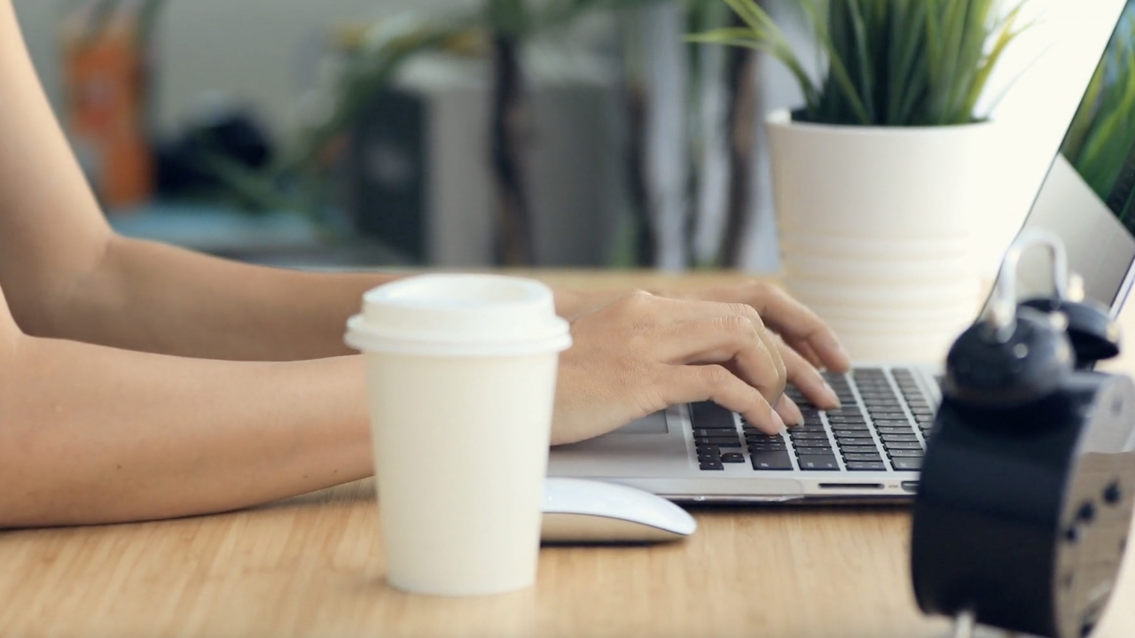 Woman typing on a computer at a desk.