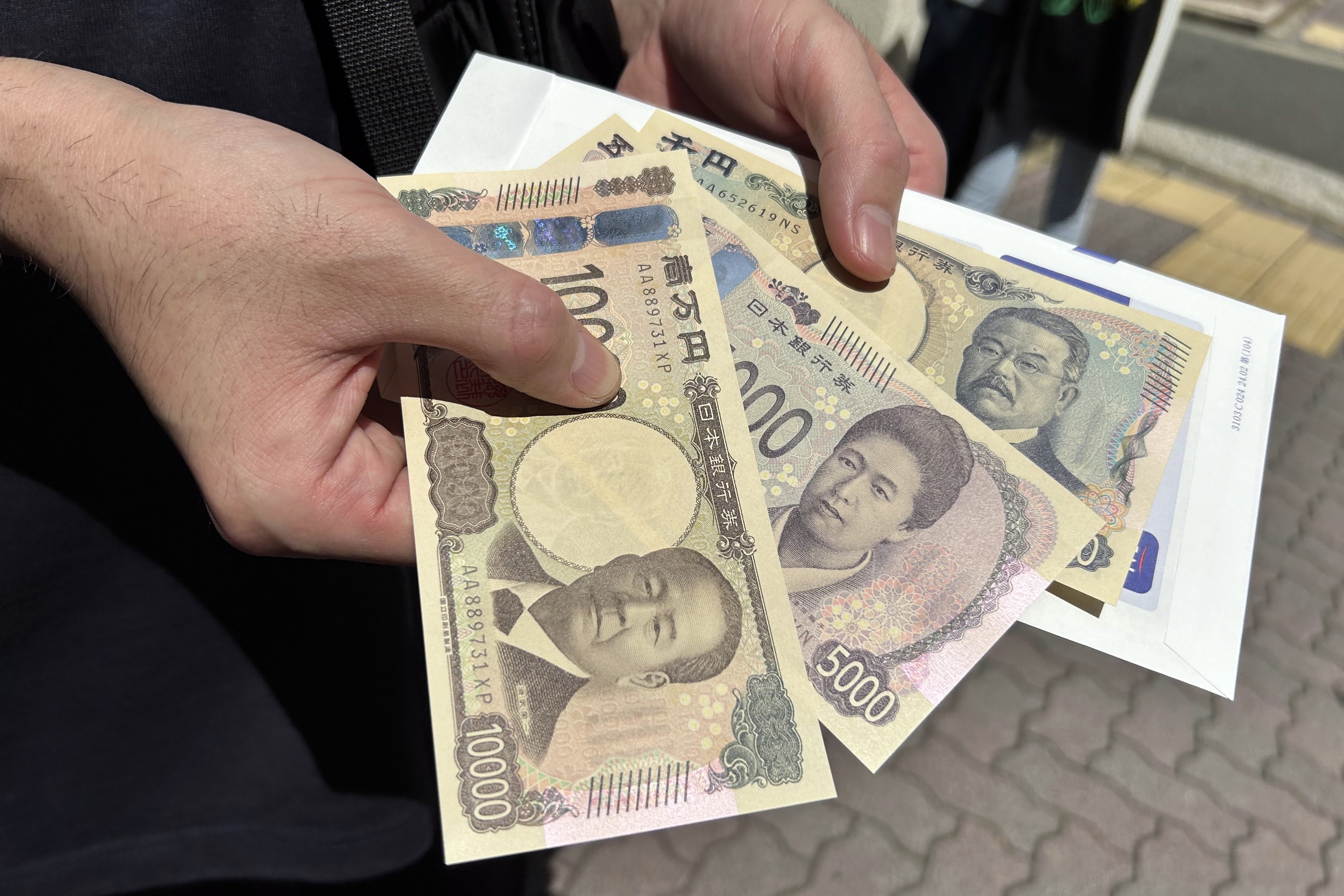 A person shows new 10,000, 5,000 and 1,000 Yen banknotes after he withdrew bills from a ATM machine at a bank Wednesday, July 3, 2024, in Tokyo.
