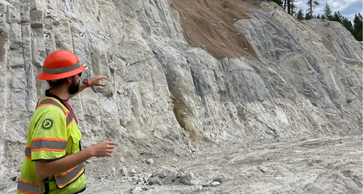 Project Engineer Alex Deduck points out pinned mesh on Cut 2 along Idaho 55. 