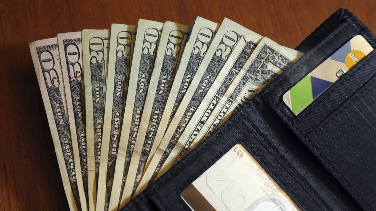 Cash is fanned out from a wallet in North Andover, Mass.