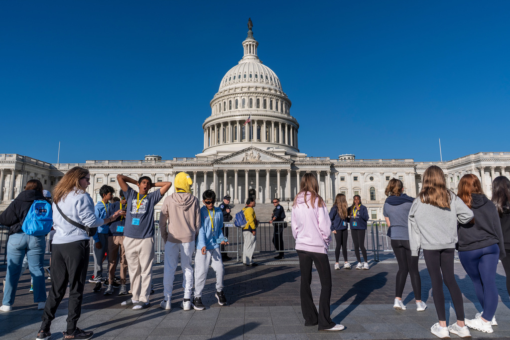 Students from Columbus, Ohio, wait outside a barrier as U.S. Capitol Police watch over the East Plaza where congressional leaders will have a news conferences on the government shutdown at the Capitol in Washington, Wednesday, Oct. 15, 2025.