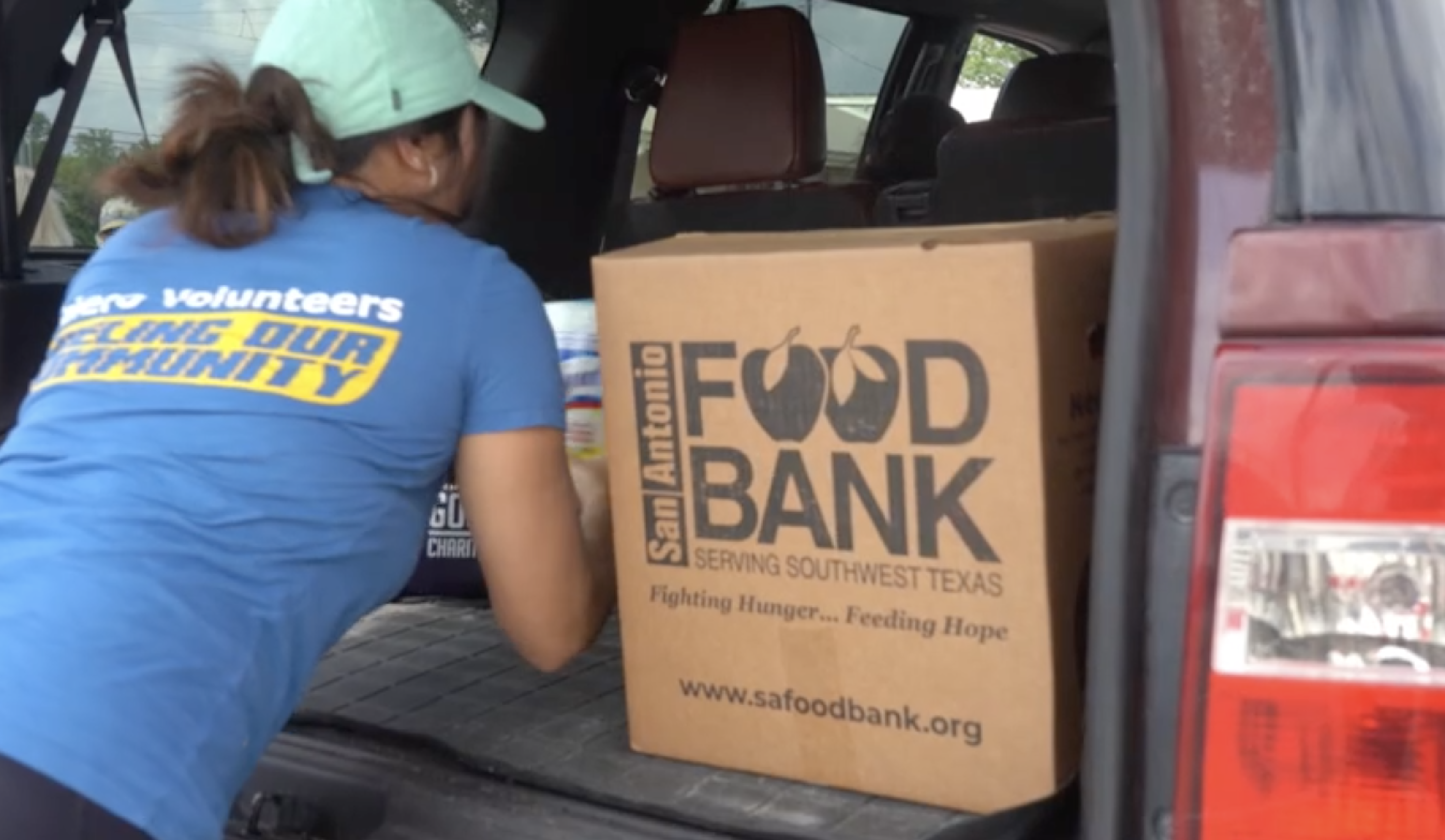 A volunteer loads boxes of food from the San Antonio Food Bank.
