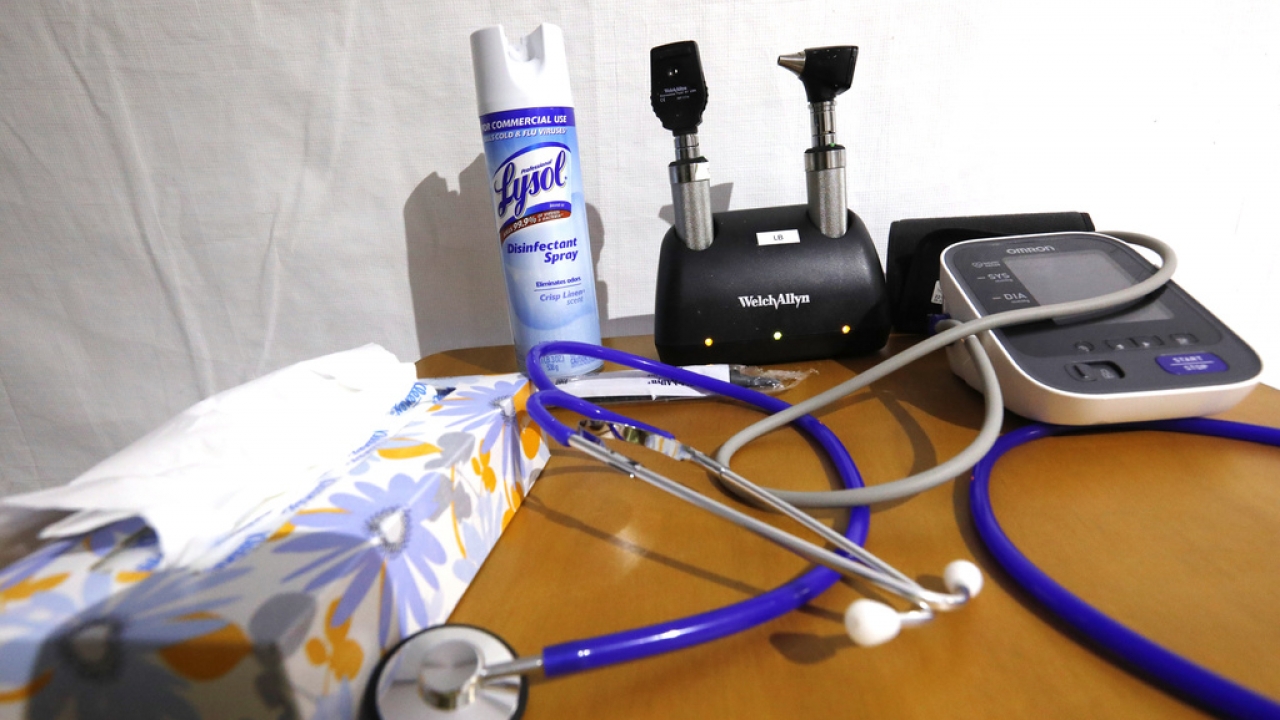 A stethoscopes and blood pressure monitor sit on a rolling table.