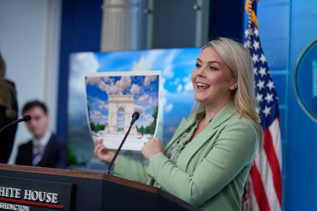 White House press secretary Karoline Leavitt holds up an artist rendering of the new triumphal arch as she speaks with reporters in the James Brady Press Briefing Room at the White House, Wednesday, April 15, 2026, in Washington. 