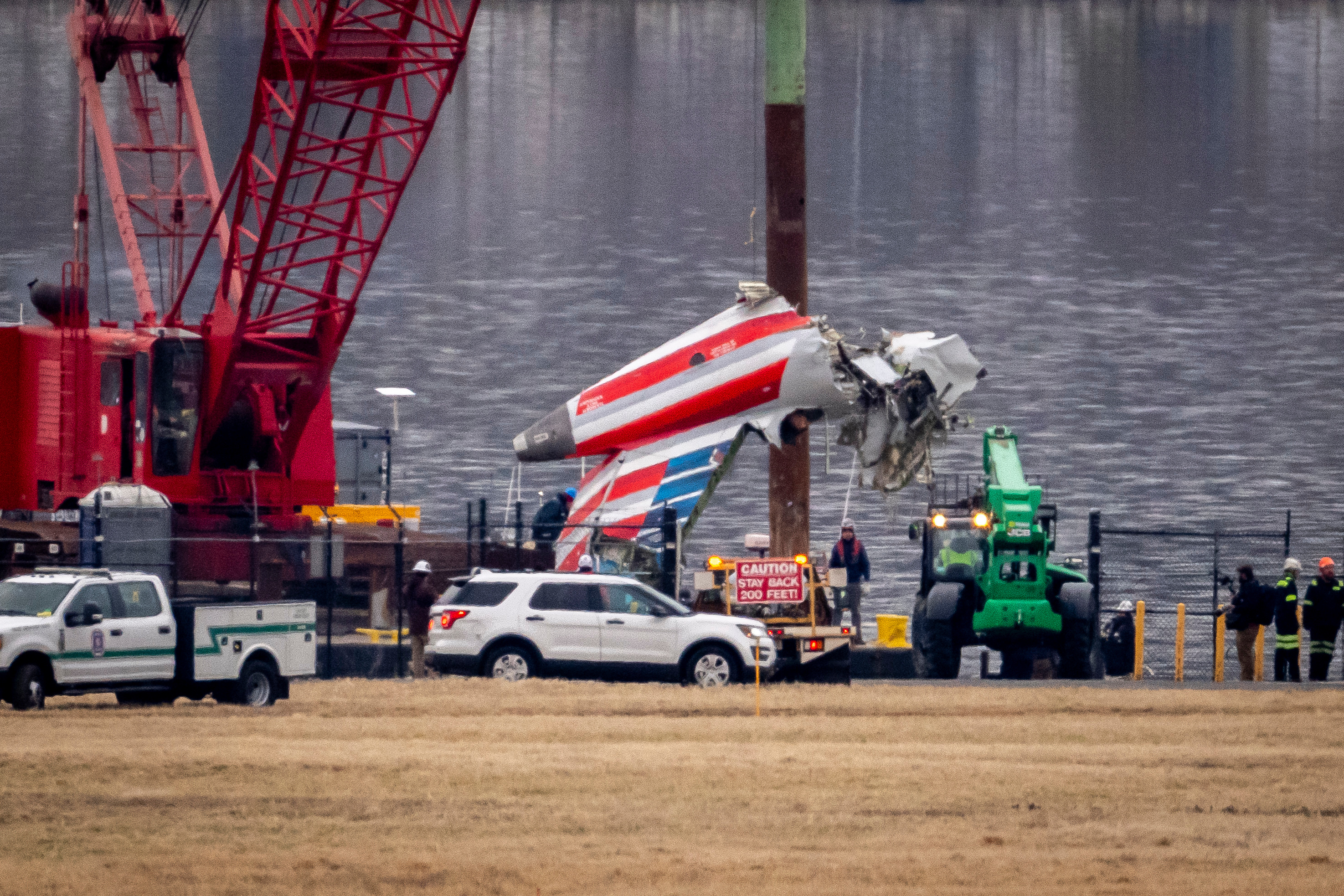FILE - A crane offloads a piece of wreckage from a salvage vessel onto a flatbed truck, near the wreckage site in the Potomac River of a mid-air collision between an American Airlines jet and a Black Hawk helicopter, at Ronald Reagan Washington National Airport, Feb. 5, 2025, in Arlington, Va. 