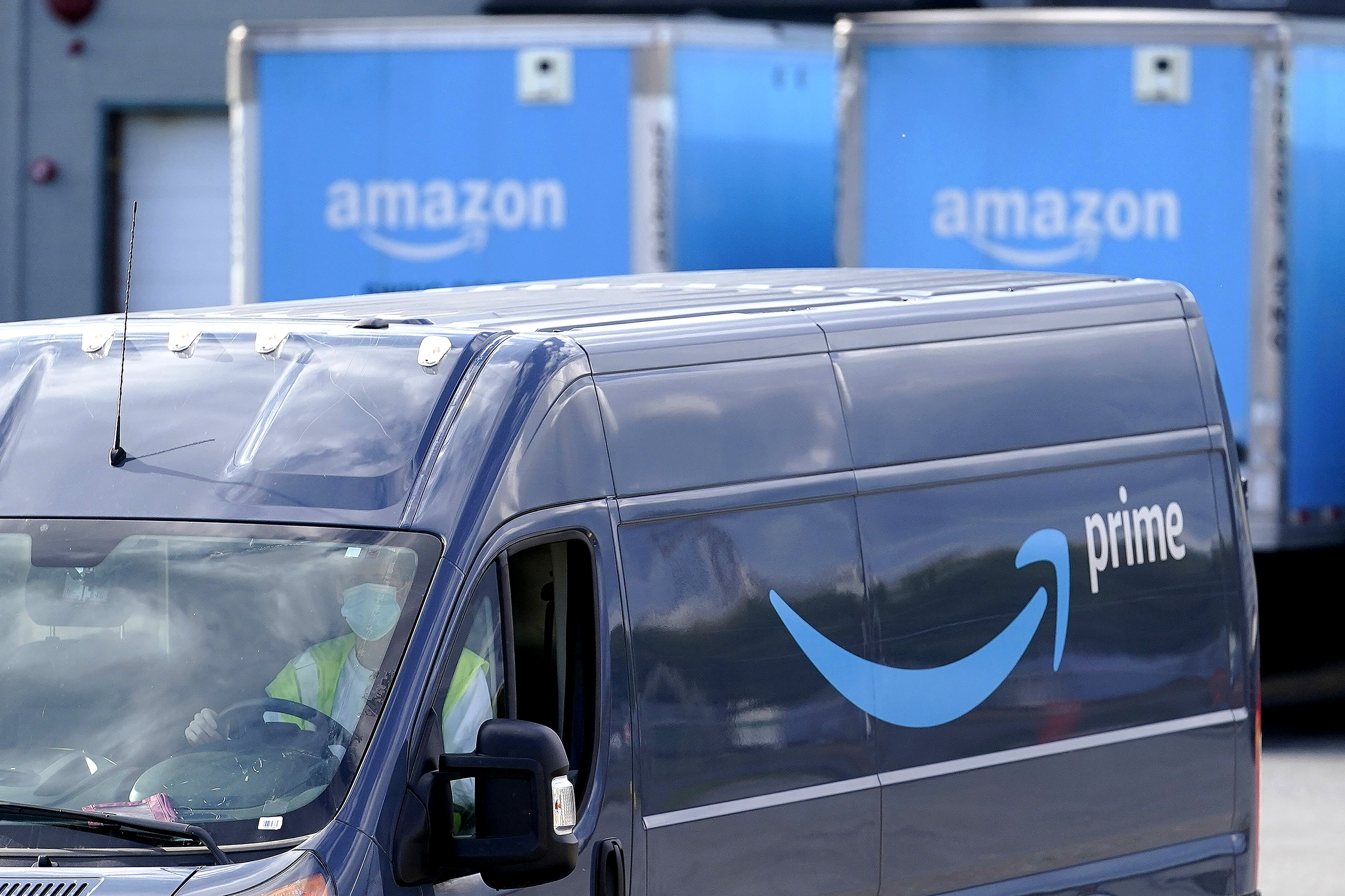 FILE - An Amazon Prime logo appears on the side of a delivery van as it departs an Amazon Warehouse location.