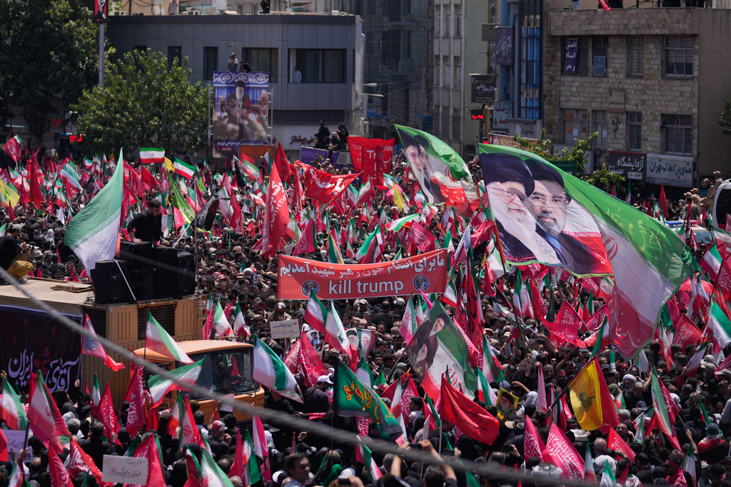 Iran Khamenei Mourners carry Iranian flags, depicting the late Iranian Supreme Leader Ayatollah Ali Khamenei, left, and Iran's new Supreme Leader Mojtaba Khamenei, and a banner reading, "kill trump," during the funeral procession of the late Iranian Supreme Leader Ayatollah Ali Khamenei in Tehran, Iran, Monday, July 6, 2026. 