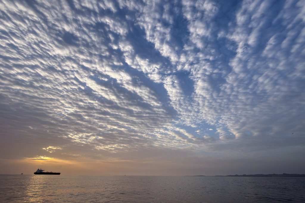 The sun rises behind a tanker anchored in the Strait of Hormuz off the coast of Qeshm Island, Iran, Saturday, April 18, 2026.