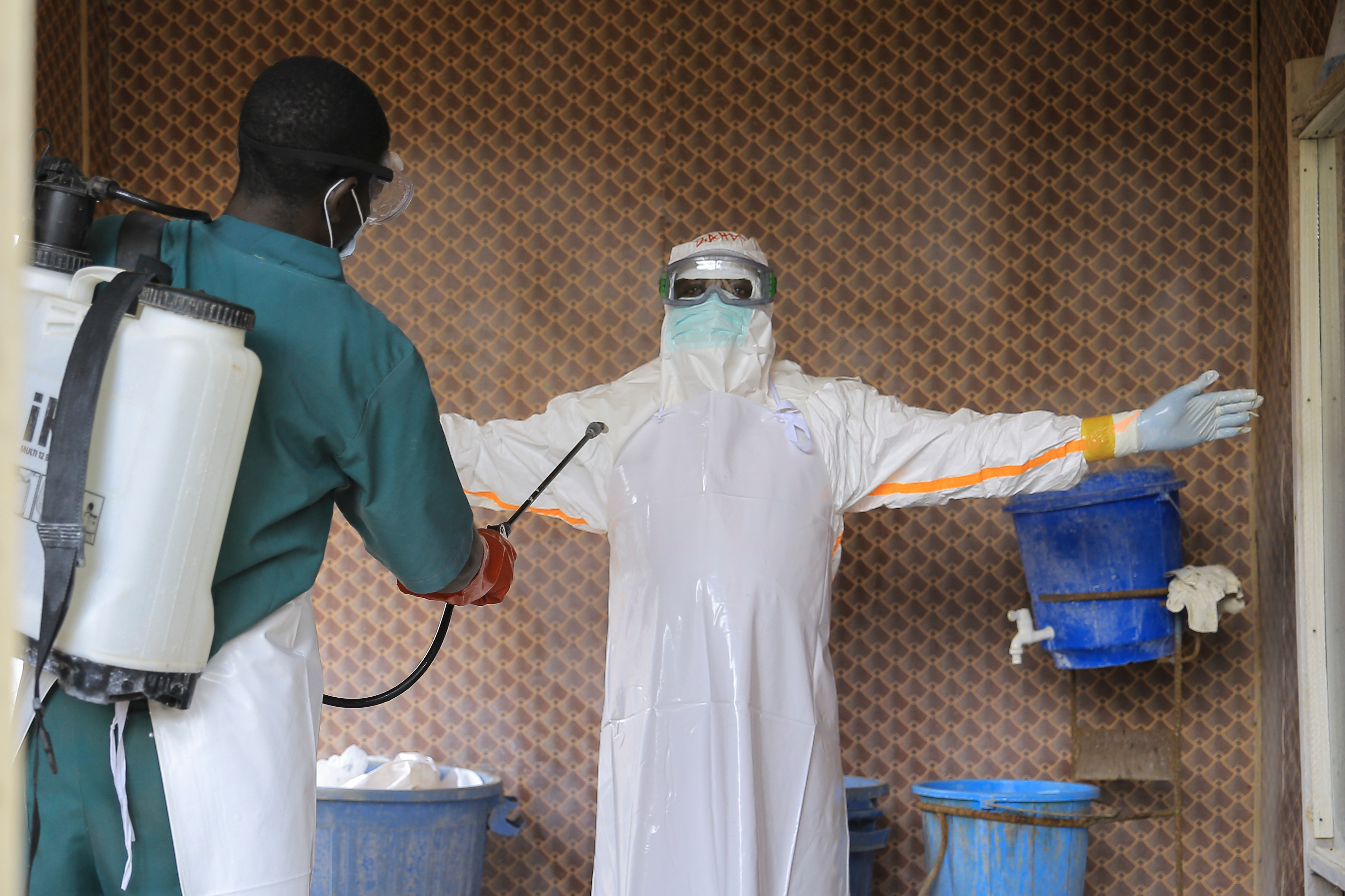 A healthcare worker in protective clothing is disinfected by a colleague inside a treatment center for Ebola patients in Beni, North Kivu province, eastern Congo, Saturday, Sept. 26, 2026.