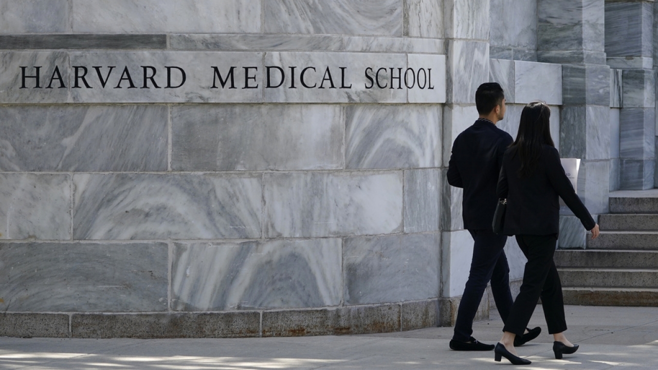 Pedestrians walk towards the Harvard Medical School, Aug. 18, 2022, in Boston.
