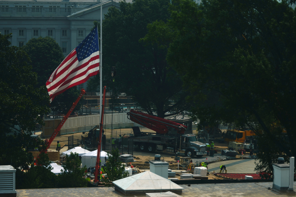 Workers build a helipad for Marine One, from right, as a flag flies at half staff in honor of the late Sen. Lindsey Graham, R-S.C., on the South Lawn of the White House, Friday, July 17, 2026, in Washington. 