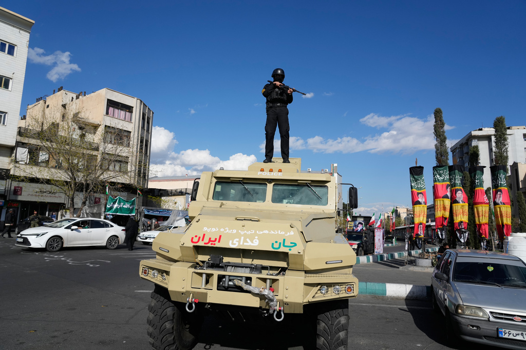 A member of police special forces stands guard on top their car at the Enqelab-e-Eslami, or Islamic Revolution, square in downtown Tehran, Iran, Monday, March 30, 2026. 