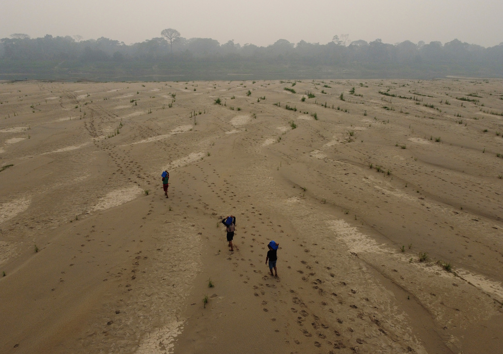 FILE - Residents transport drinking water from Humaita to the Paraizinho community, along the dry Madeira River, a tributary of the Amazon River, during the dry season, Amazonas state, Brazil, Sept. 8, 2024. 