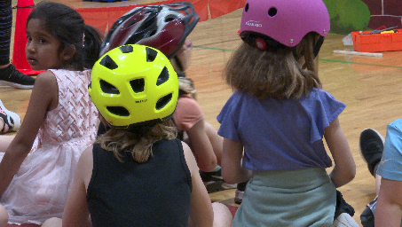 Early literacy students prepare to ride bikes