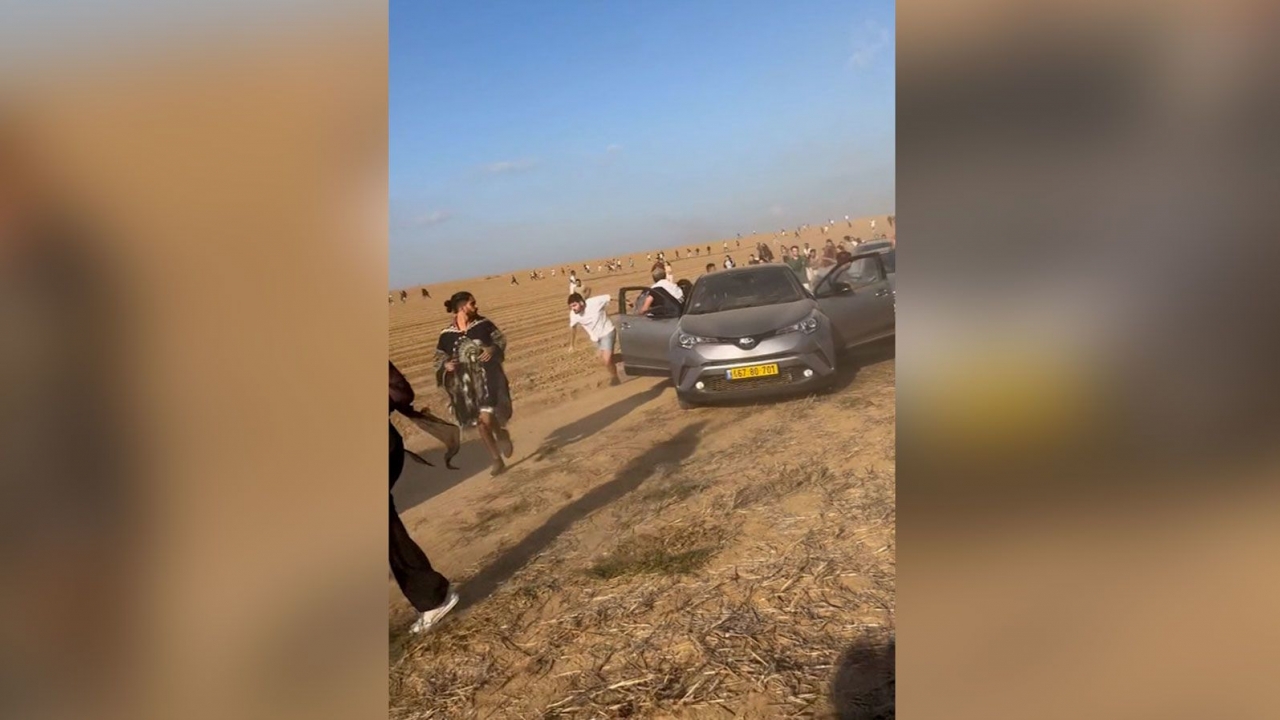 People attending a music festival in rural farmland in Israel flee Hamas militants who opened fire abducted people.