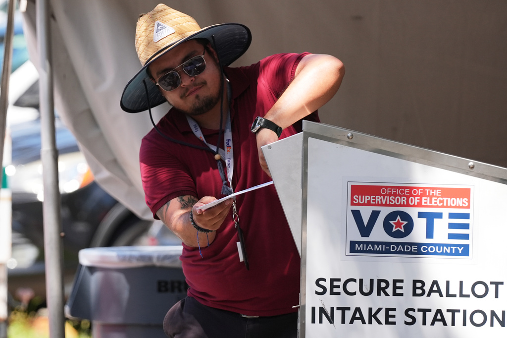 An election worker places a vote-by-mail ballot into a secure bin at the Miami-Dade County Supervisor of Elections Office during the Florida primary election in Doral, Fla., Tuesday, Aug. 18, 2026.