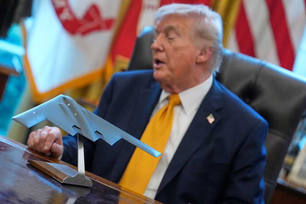 President Donald Trump speaks in the Oval Office of the White House, Monday, March 16, 2026, in Washington, with a model of a B-2 stealth bomber in front.