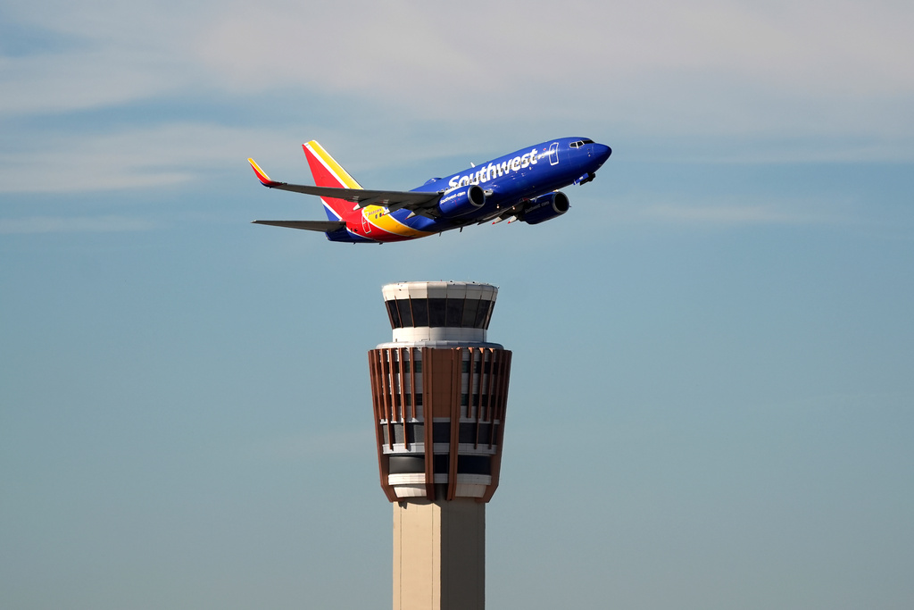 A Southwest Airlines jet flies past the air traffic control tower at Phoenix Sky Harbor International Airport Saturday, Nov. 8, 2025, in Phoenix. 