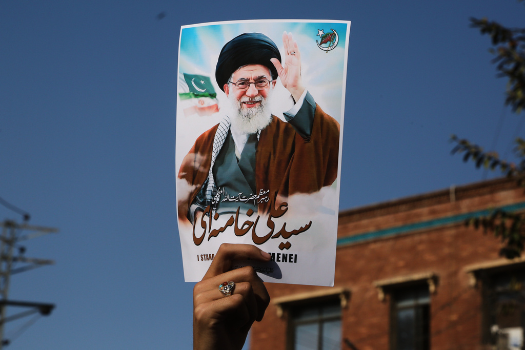 A Shiite Muslim hold the portrait of Iranian Supreme Leader Ayatollah Ali Khamenei during a rally to condemn his killing, in Peshawar, Pakistan, Sunday, March 1, 2026.