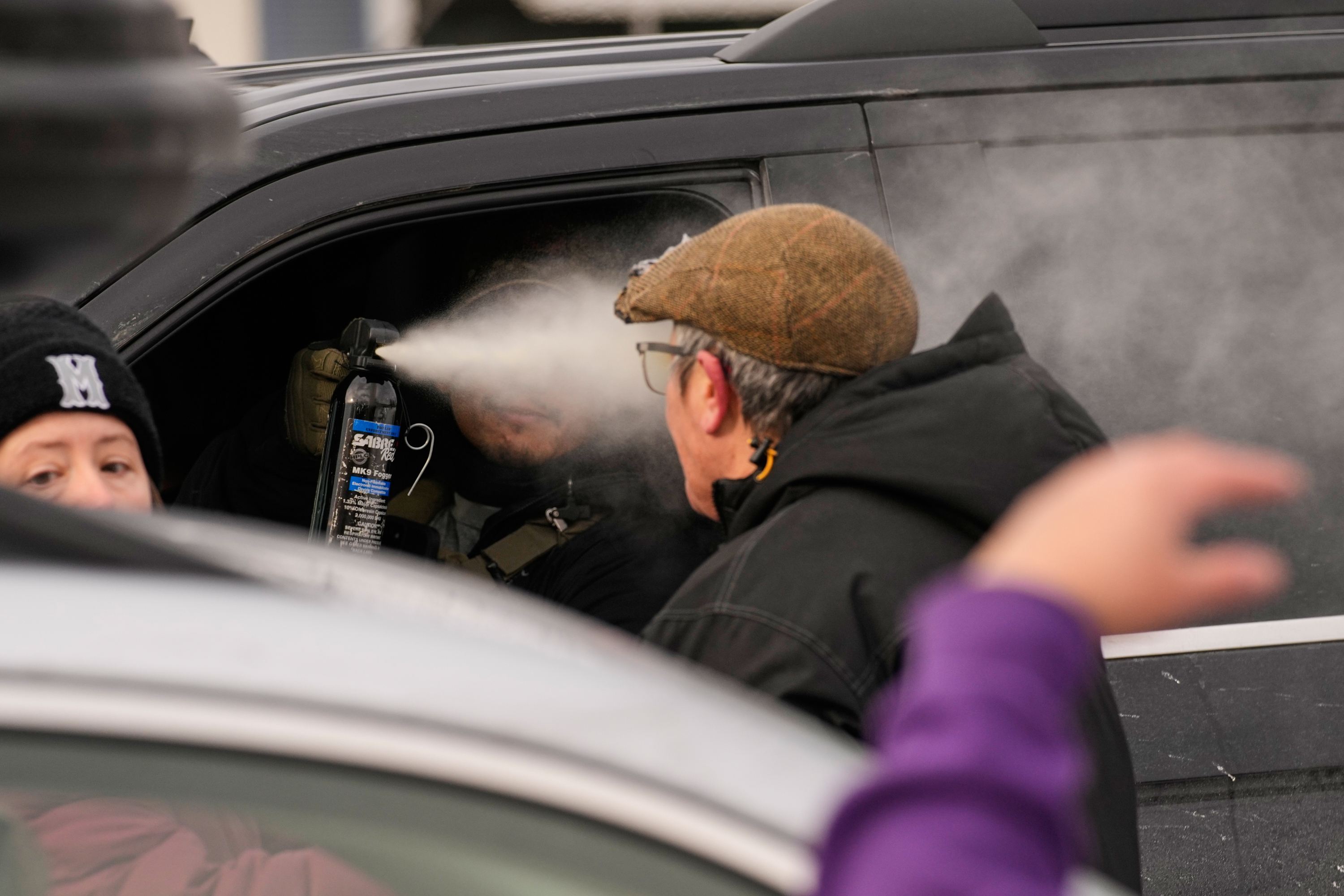 A federal immigration officer deploys pepper spray as officers make an arrest Sunday, Jan. 11, 2026, in Minneapolis. 