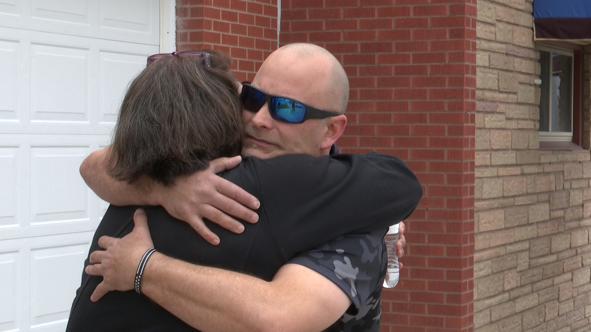 Rock and Dabney embrace outside of Bullis Mortuary