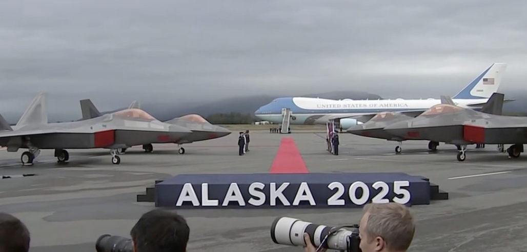Air Force One is flanked by fighter jets.