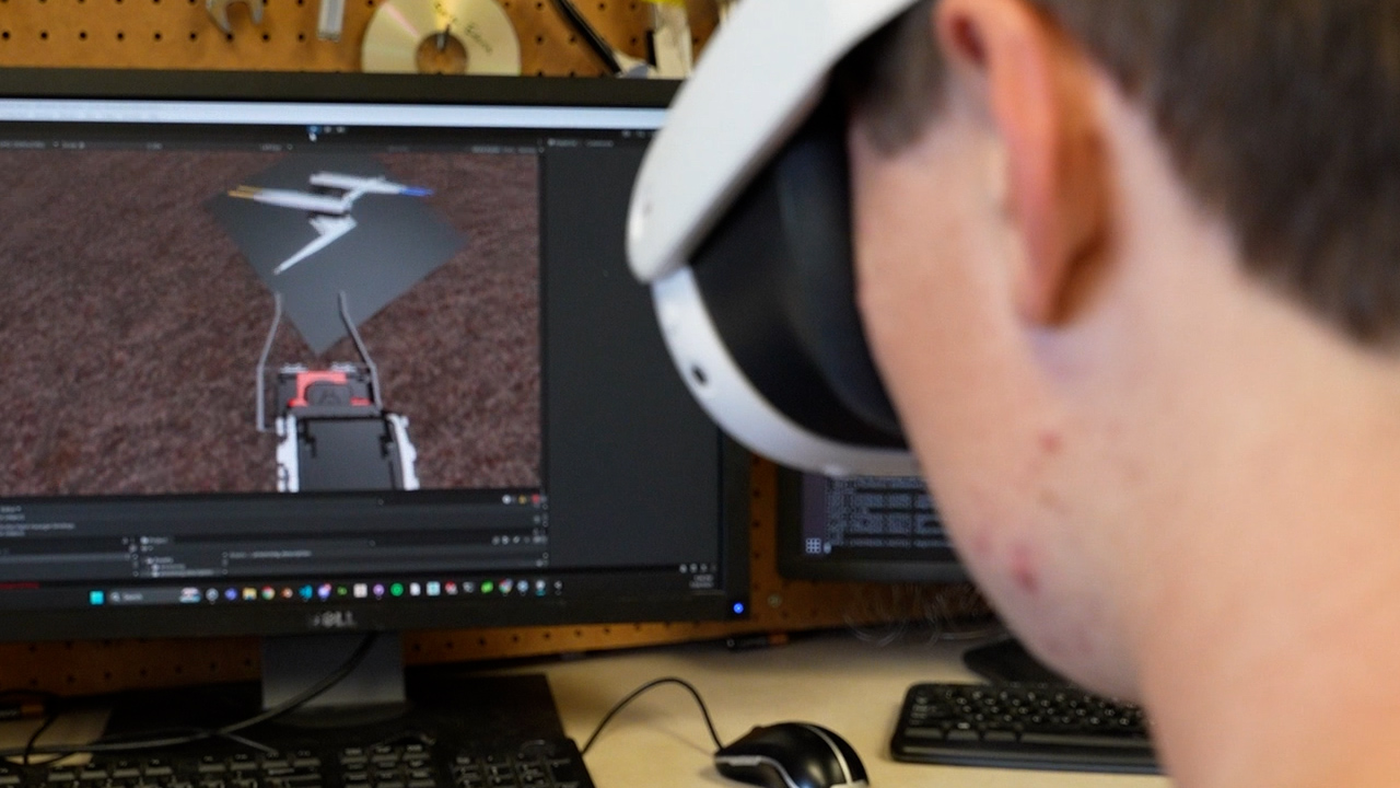 Xavier O'Keefe wears VR goggles to use the 'digital twin' simulation of the 'Armstrong' robot.