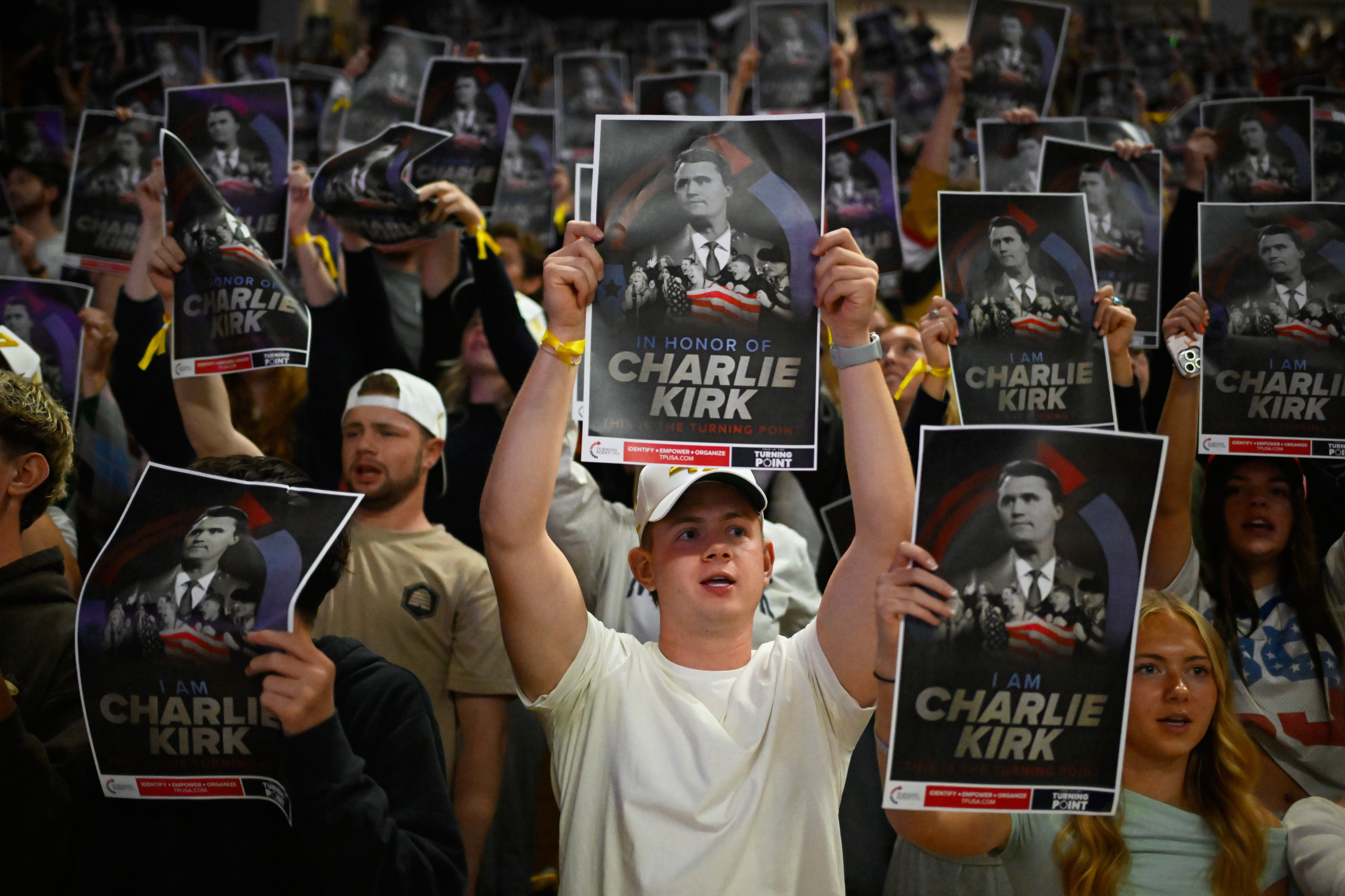 People hold posters of Charlie Kirk during a Turning Point USA rally at Utah State University, as a part of the organization's push to memorialize Kirk, Tuesday, Sept. 30, 2025, in Logan, Utah. 