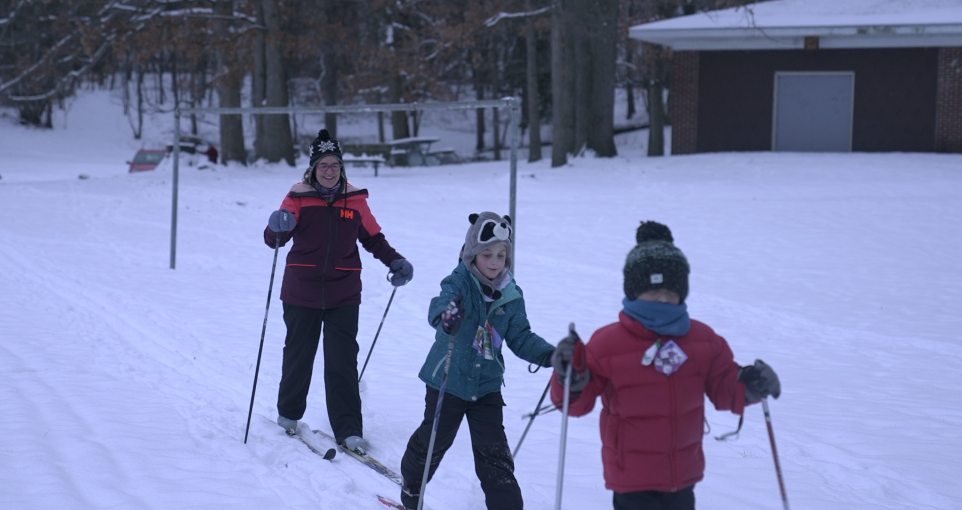 Family enjoying cross country skiing at Bancroft Park in Lansing. 