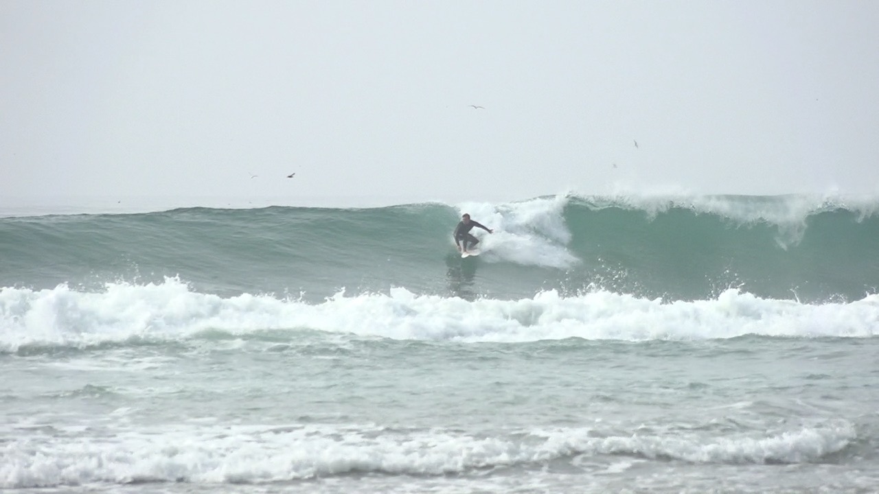 Surfers catch waves at Black's Beach ahead of high waves on Thursday.