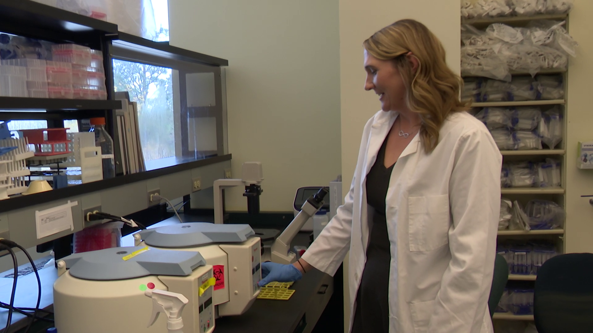 Tiffany Hensley-McBain demonstrates a centrifuge in a lab at the McLaughlin Research Institute