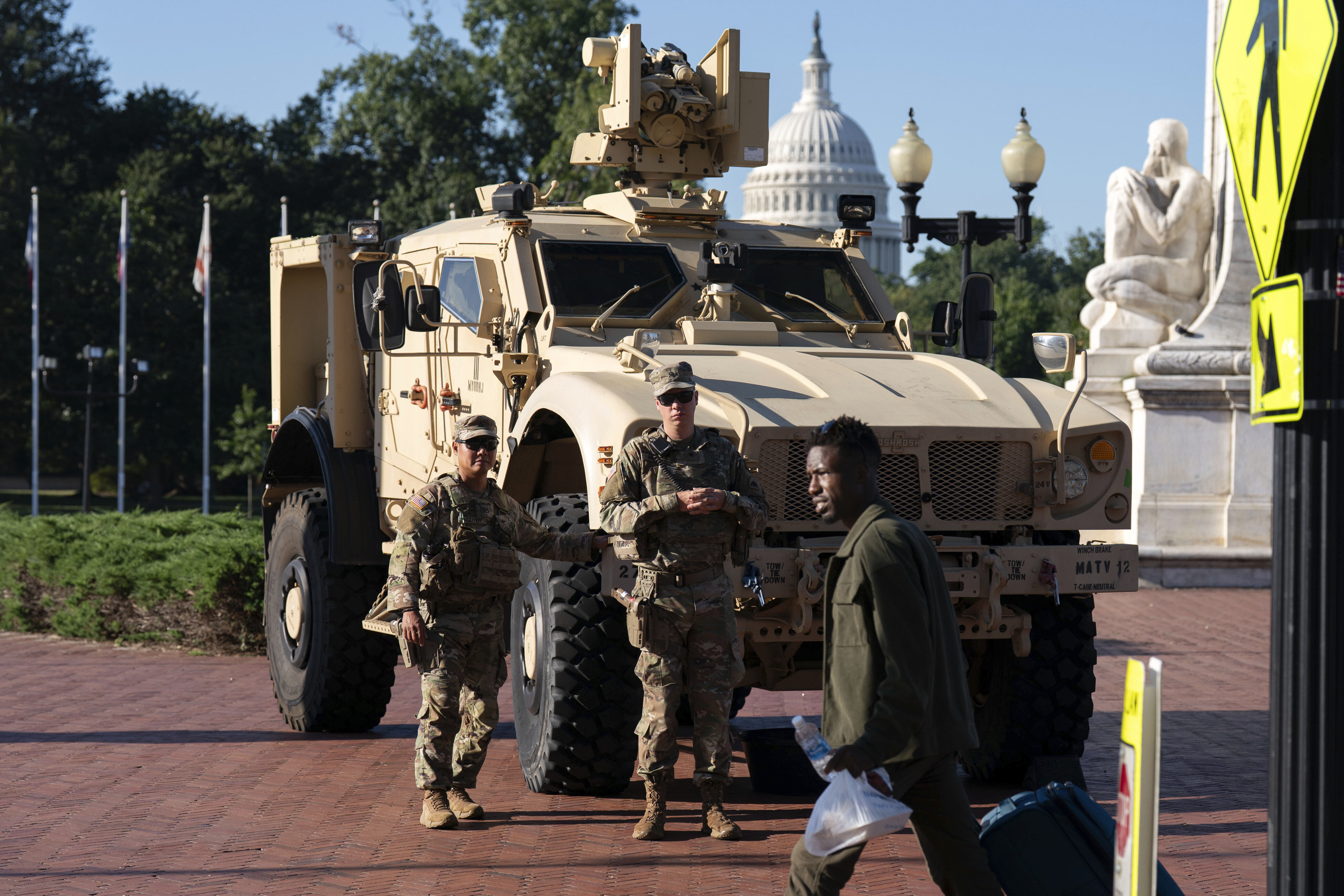 Members of the District of Columbia National Guard standing next to an MATV vehicle scan the area as they patrol outside Union Station, Monday, Sept. 1, 2025, in Washington. 