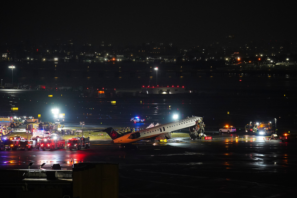 An Air Canada Jet sits on the runway at LaGuardia Airport, Monday, March 23, 2026, after colliding with a Port Authority aircraft rescue and firefighting vehicle in New York.